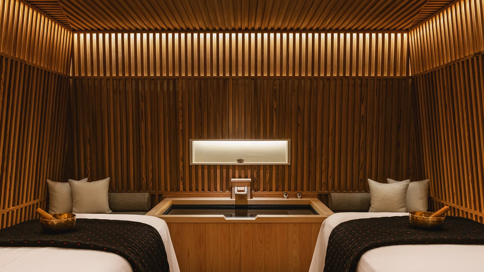 Six Senses Kyoto spa interior with warm timber walls and twin treatment beds